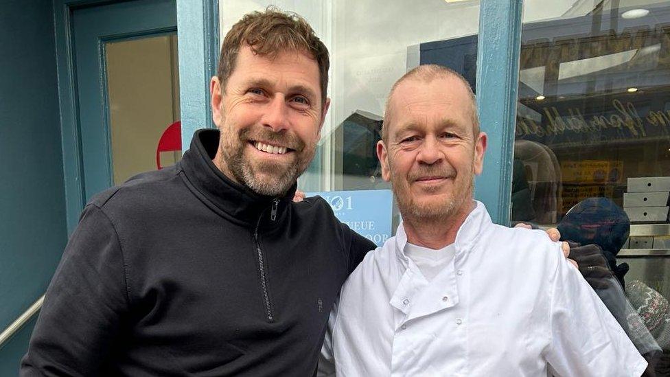 Grant Holt with the owner of the fish shop in Cromer