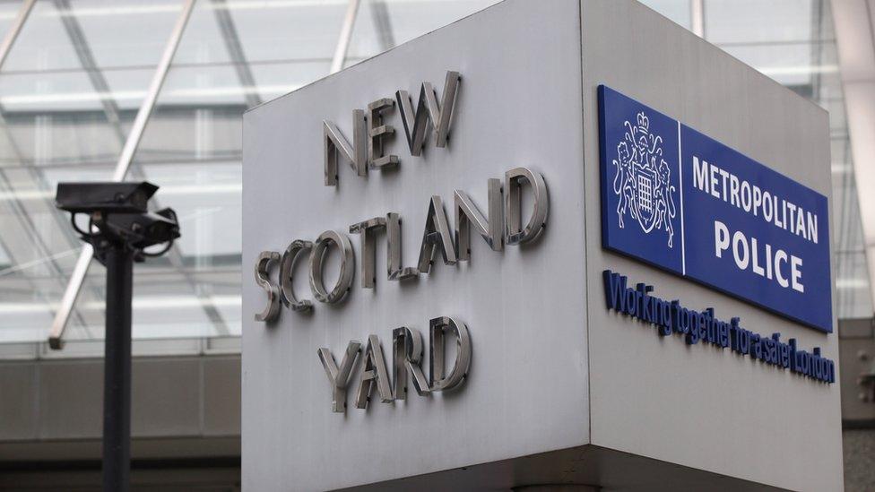 entrance to new scotland yard with a large sign saying 'New Scotland Yard' on one side and 'Metropolitan Police' on the other