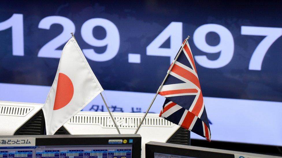 Japanese and British flags on traders' computer screens