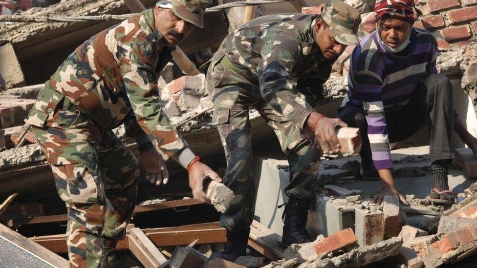 Indian soldiers and locals remove debris from a damaged building after an earthquake in Imphal, capital of the north-eastern Indian state of Manipur, Monday, Jan. 4, 2016