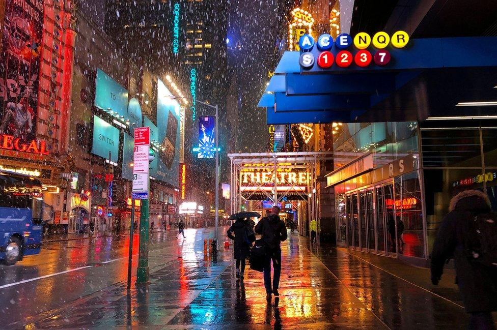 People walk to work in midtown Manhattan during a storm.