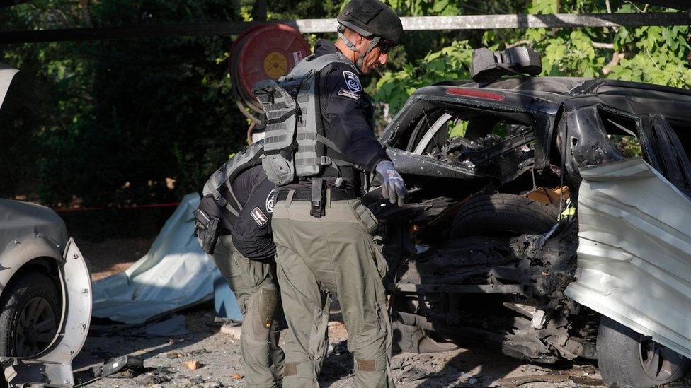 Israeli security forces inspect damage caused by a rocket fired by Palestinian militants in Gaza that landed in Sde Nitzan, southern Israel (7 August 2022)