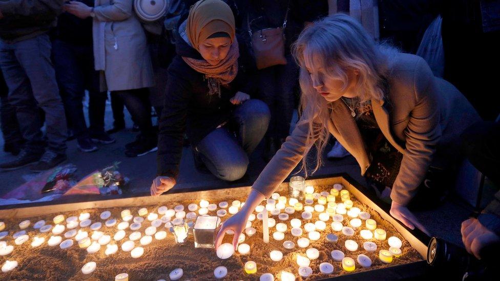 Two women lighting candles