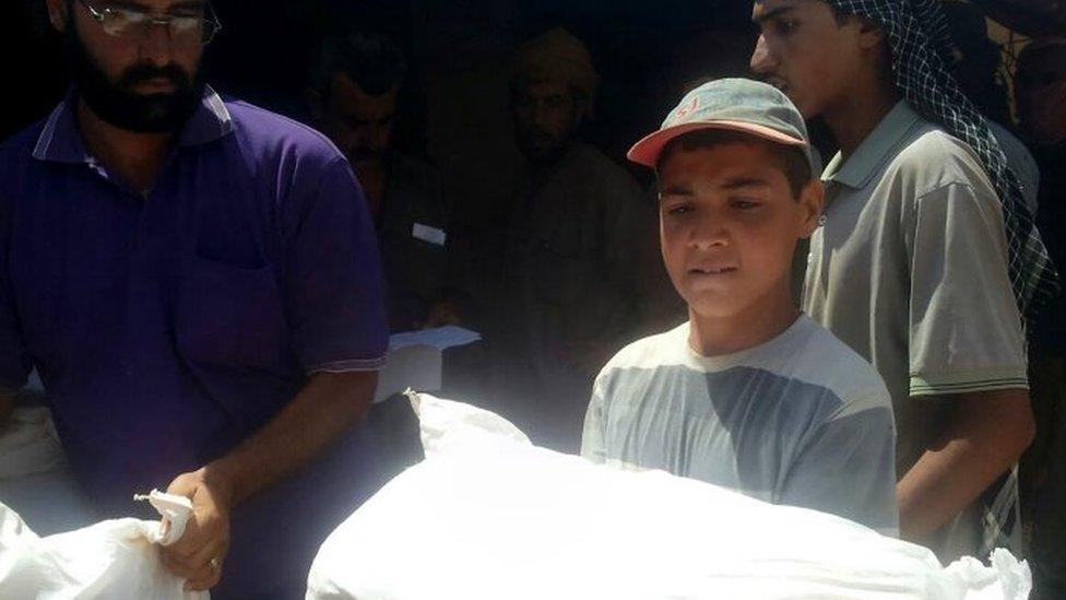 A boy holds a sack of grain on the Jordan-Syria border (04 August 2016)