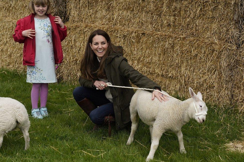 Catherine holds a lamb on a lead