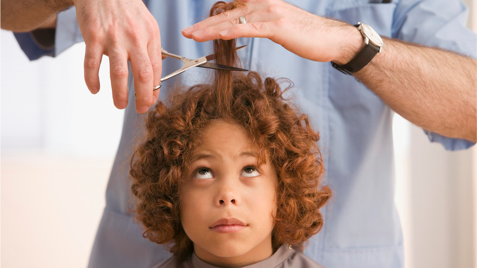 A young boy gets his haircut