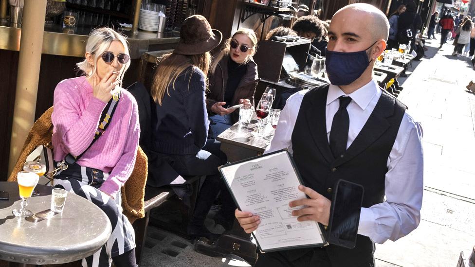 People have outdoor drinks in Soho, London