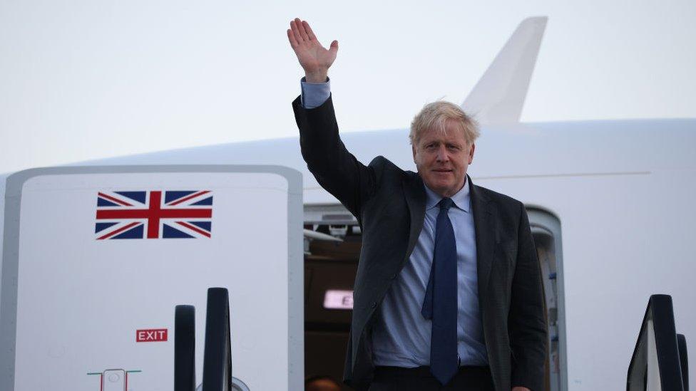 boris johnson waving from a plane