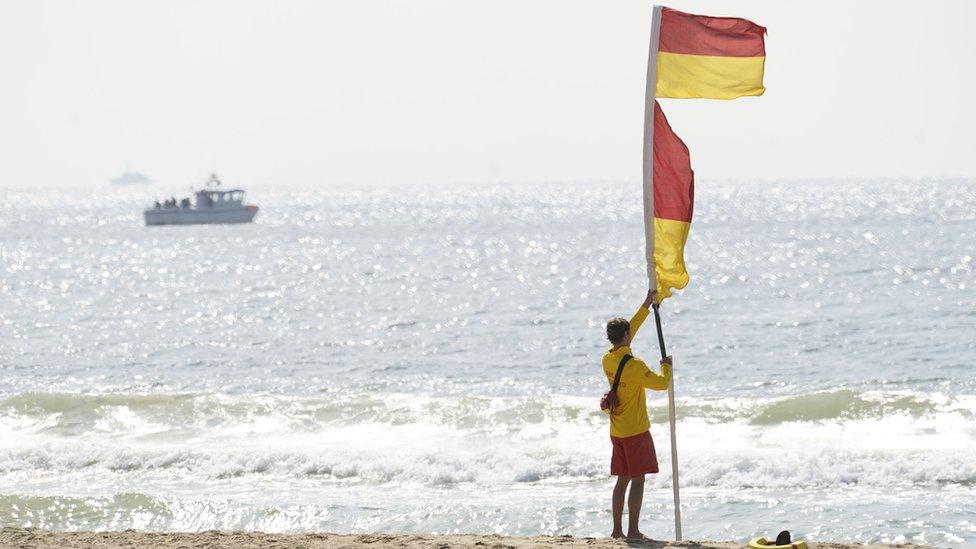 Lifeguard with a red and yellow flag