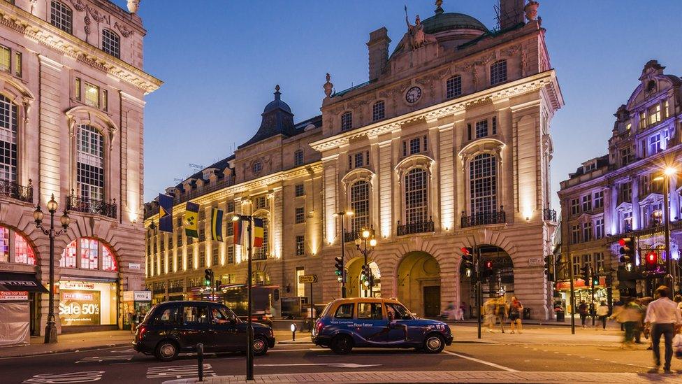 Two black cabs drive through Piccadilly