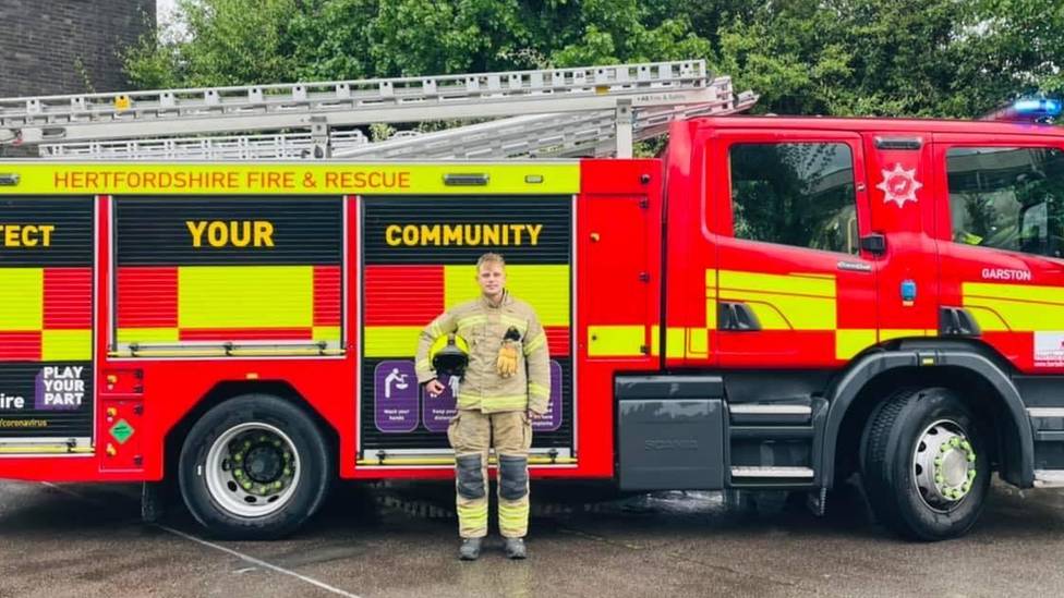 Liam in front of his fire engine