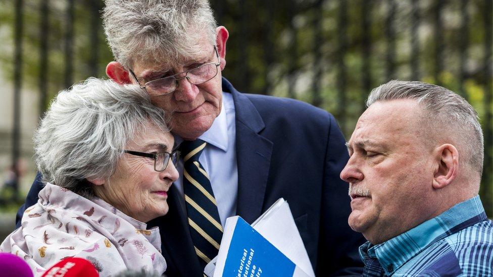 Kate McCausland is embraced by Jon McCourt and accompanied by John Heaney outside Belfast's Laganside Courts