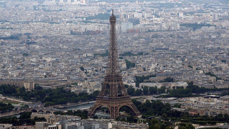 An aerial view shows the Eiffel tower, the Seine River, and the Paris skyline, France