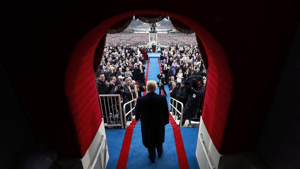 Trump walks through the doorway to the inauguration podium