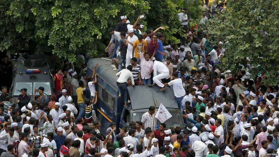 Members of the Patel community climb a police vehicle as they attend a protest rally in Ahmedabad, India, August 25, 2015.