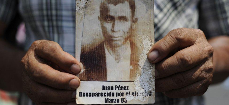 A man holds a portrait of Juan Perez disappeared during the internal armed conflict, during a protest against the quashing of the 80-year sentence for genocide of former Guatemalan dictator General Efrain Rios Montt outside Constitutional Court (CC) of Guatemala on May 24, 2013 in Guatemala city.