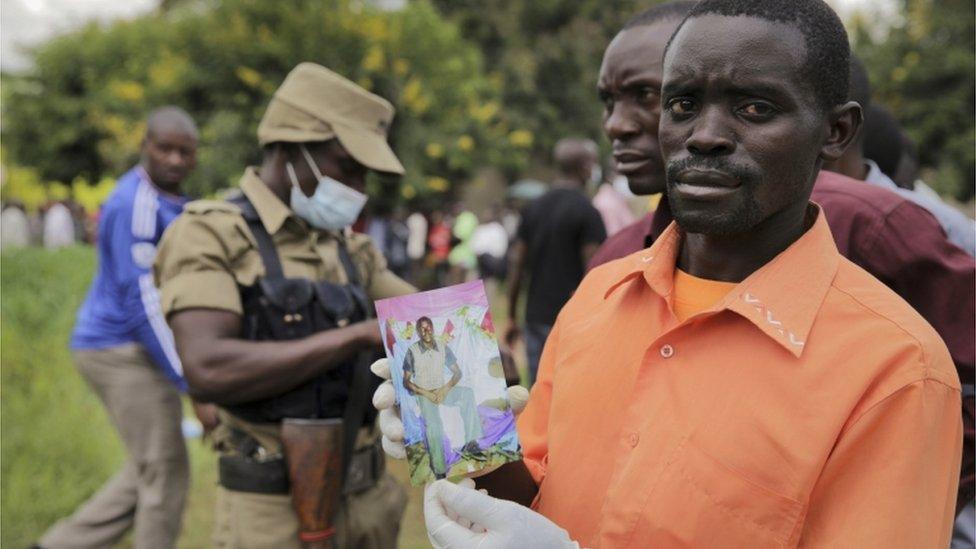A man holding a picture of his relative.