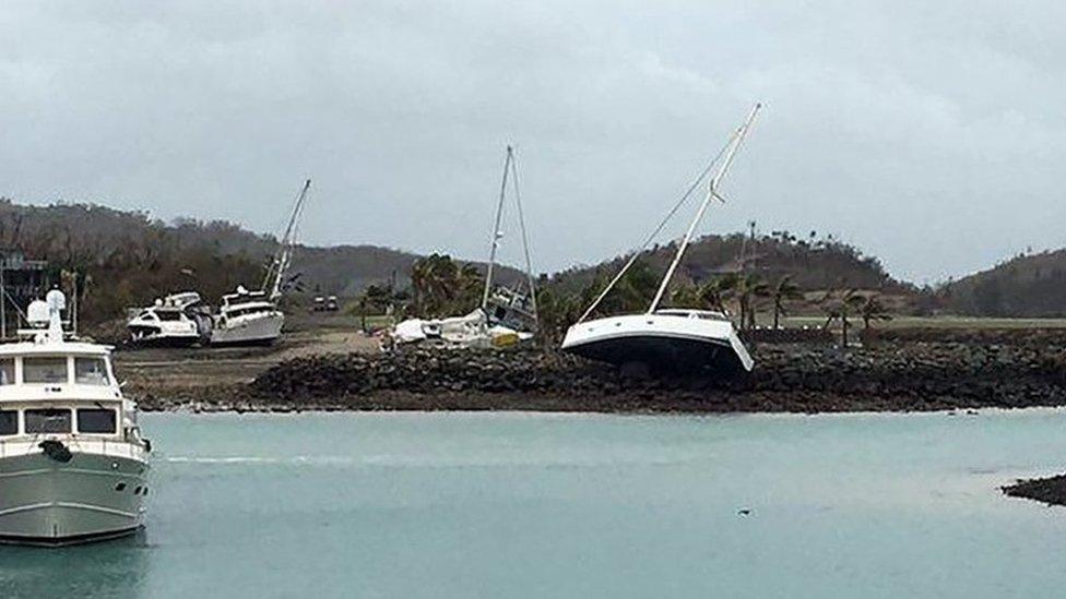 A boat (C) ran aground on Hamilton Island after strong Cyclone Debbie hit the Whitsundays Islands in Queensland on March 29, 2017