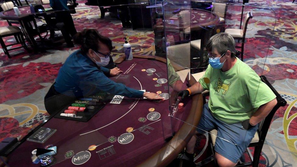 Nila Davis (L) deals cards to Becky Lewis of Texas at a blackjack table with plexiglass safety shield dividers at Excalibur Hotel ^ Casino after the Las Vegas Strip property opened for the first time since being closed in mid-March because of the coronavirus