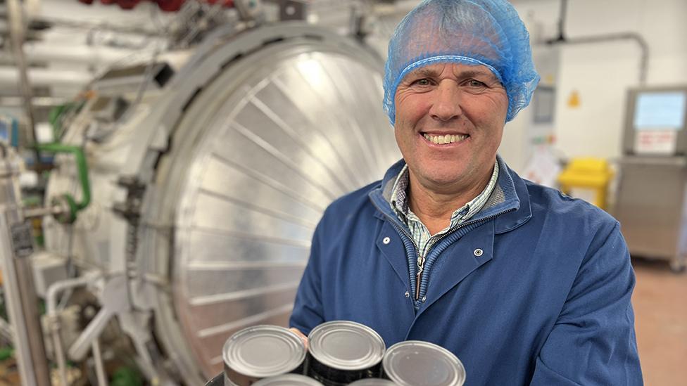 Andrew Ward holding tins of beans