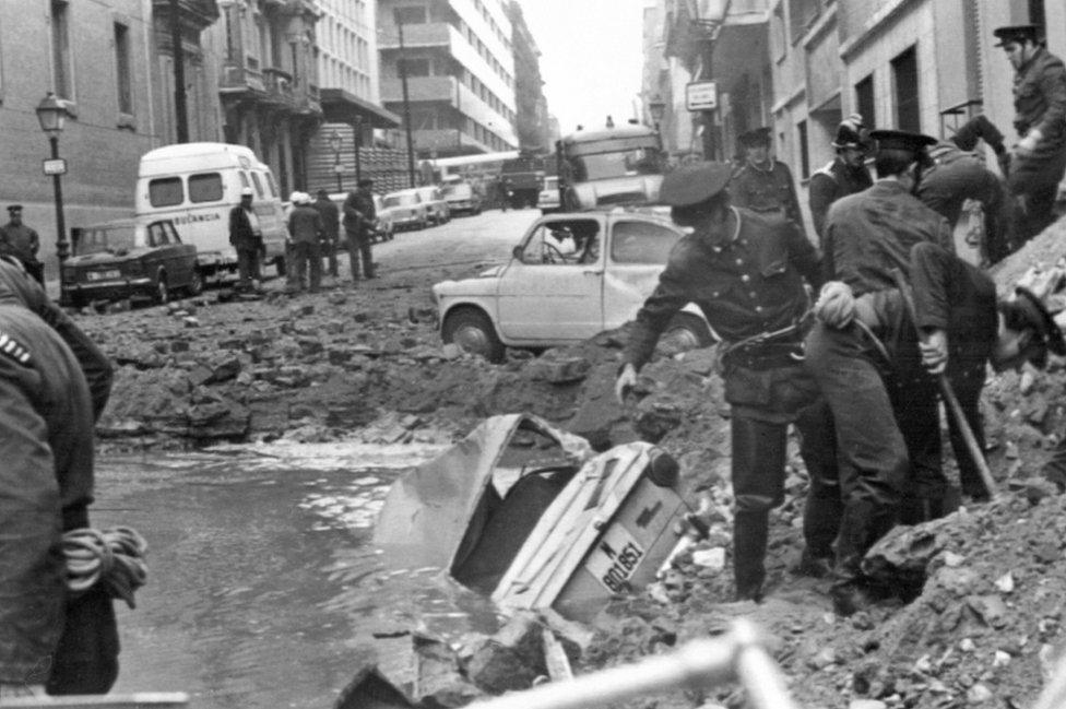 Spanish policemen search among the damage caused by a bomb attack, 20 December 1973, in which Spanish Prime Minister Luis Carrero Blanco was killed