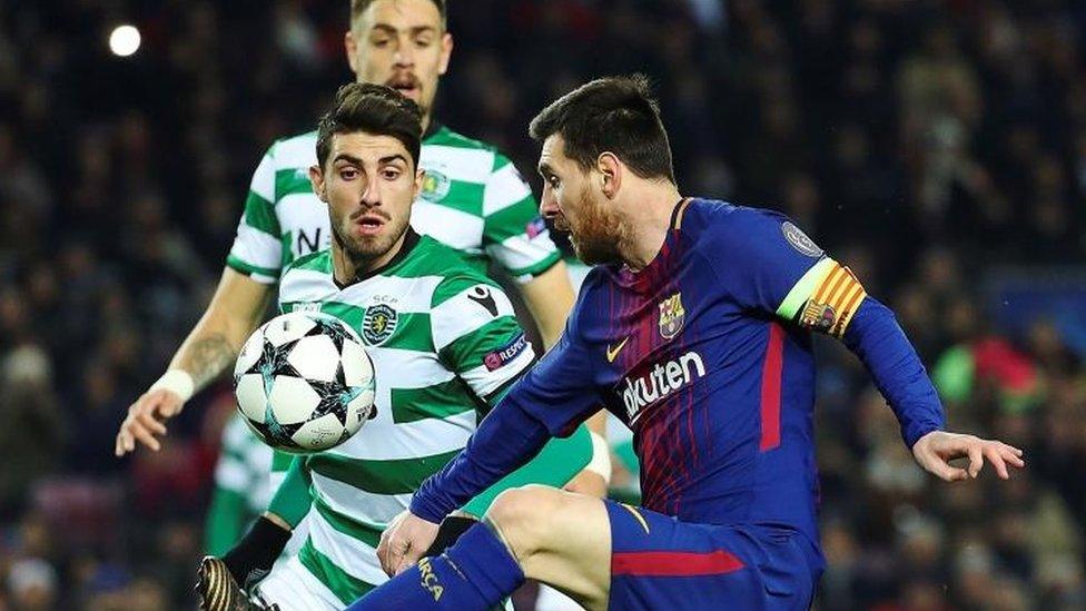 Barcelona's Leo Messi (R) vies for the ball against Sporting Lisbon