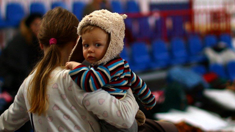 Mother holds child at a refugee centre in Poland