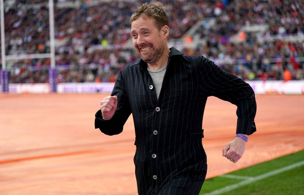 Ricky Wilson of The Kaiser Chiefs entertains the crowd during a delay to the Rugby League World Cup group A match at St James' Park, Newcastle