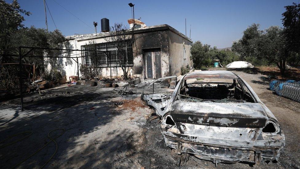 A burned out car and damaged home in the Palestinian town Turmus Aya, in the occupied West Bank, following an attack by Israeli settlers (21 June 2023)