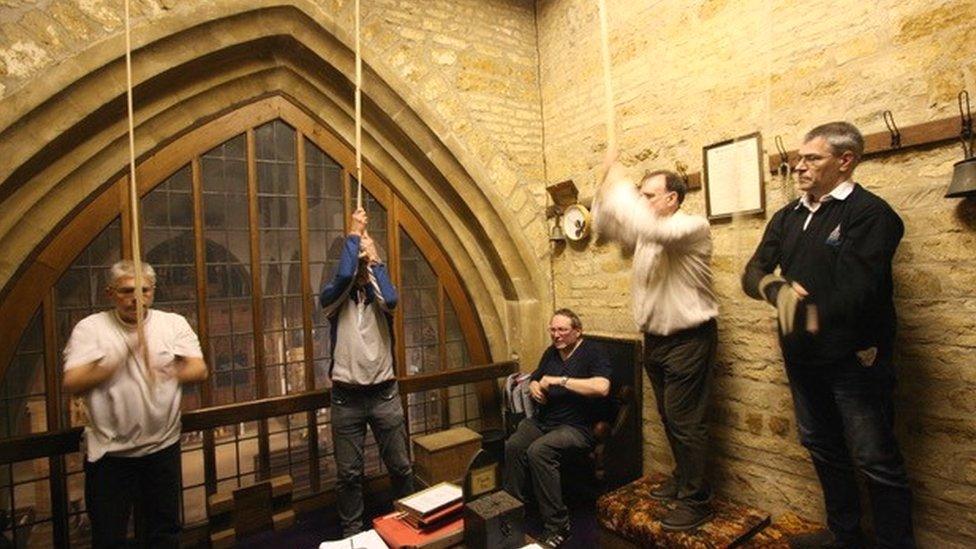 Four people pulling on bell ropes in a ringing chamber