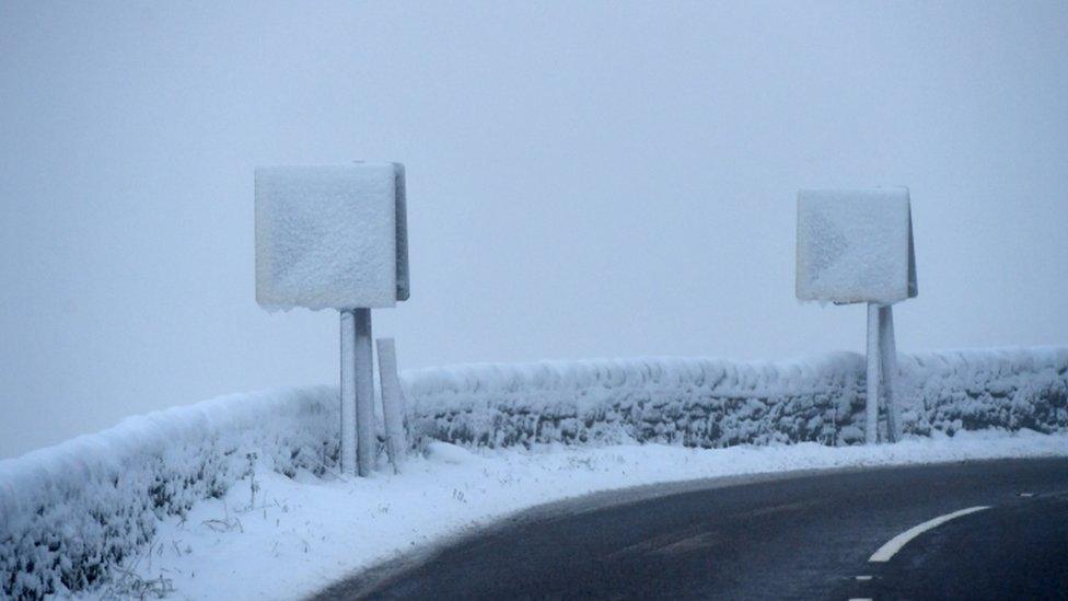 Road signs are covered with snow on the A628 Woodhead Pass in the Longdendale Valley in Derbyshire's High Peak