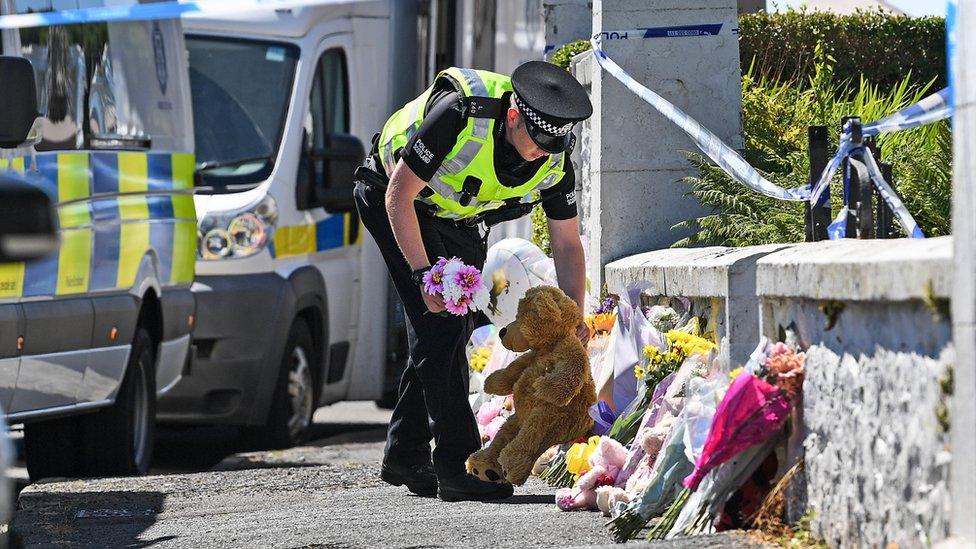 Police officer with floral tributes