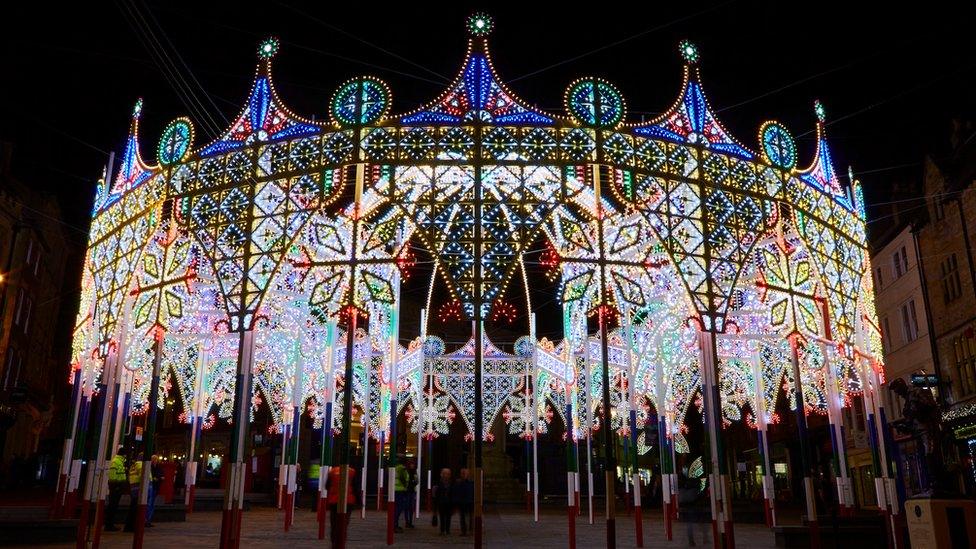 A structure shaped like an detailed crown, covered in loads of different light bulbs in different colours.