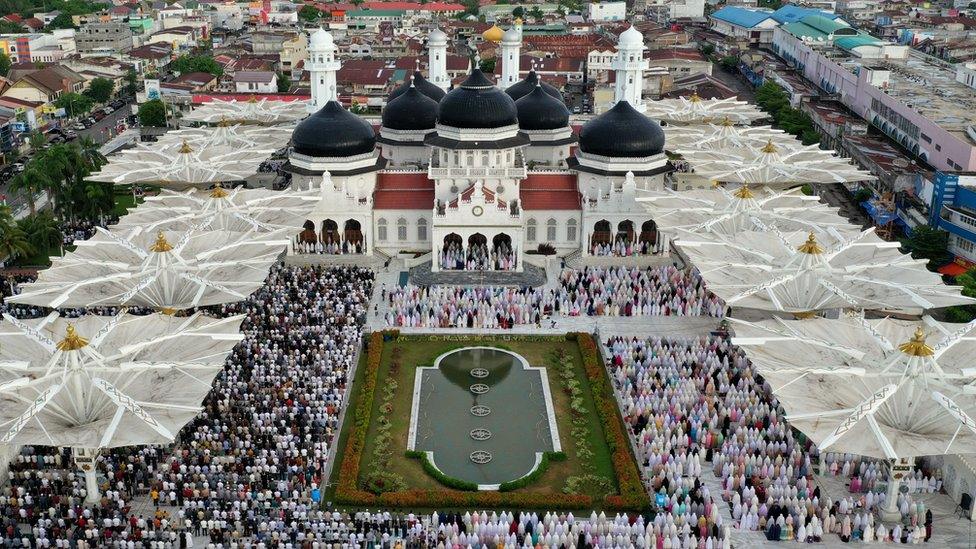 An aerial photograph shows people attending Eid al-Fitr prayers at Baiturrahman Mosque in Banda Aceh, Indonesia