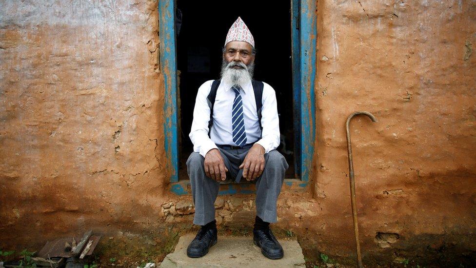 Durga Kami poses for a picture in his school uniform at home