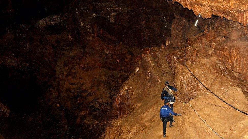 Rescue workers use ropes to climb in a Thai cave in search of a missing football team