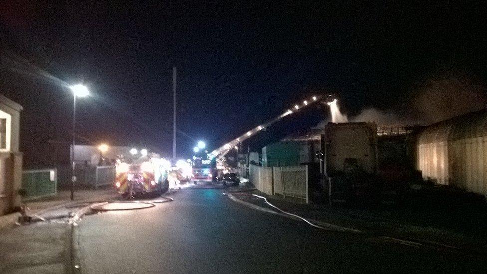 Fire engines putting out a fire at an industrial building