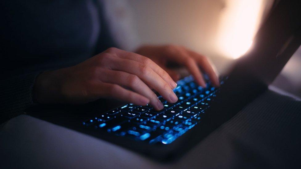 A man typing on a laptop