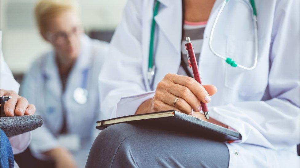 A close up of a doctor writing