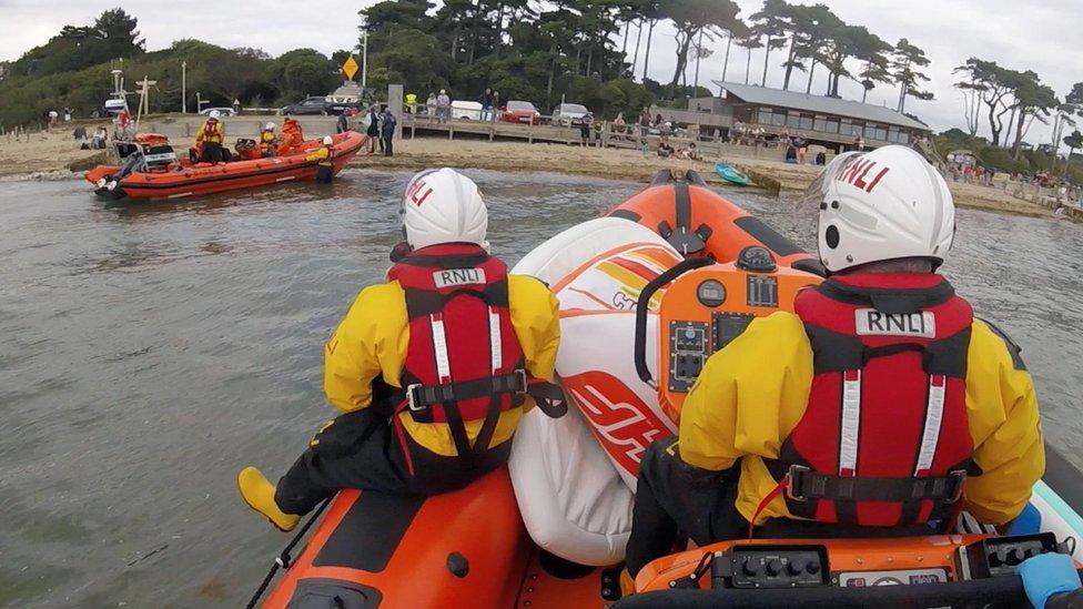 Cowes lifeboat approaches Calshot lifeboat on Lepe beach