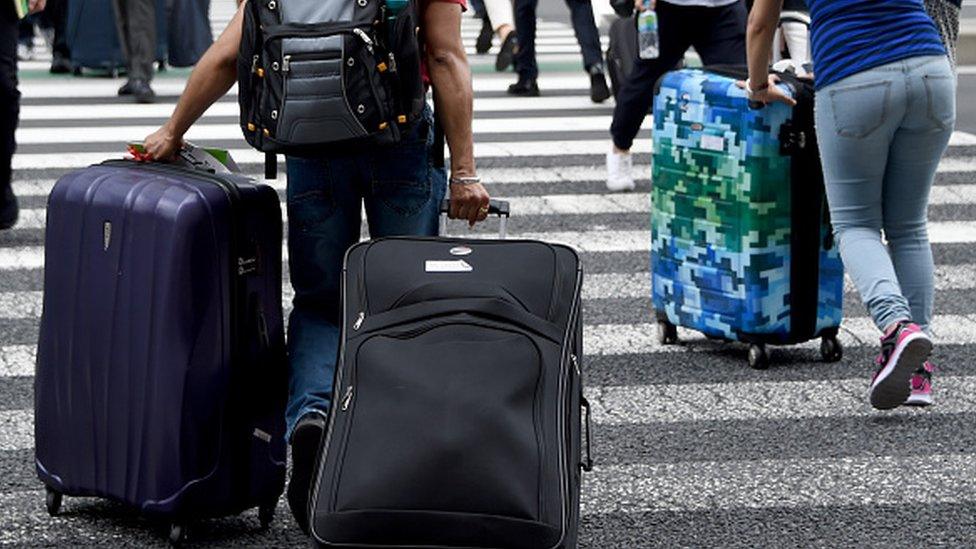 A tourist in Japan with two suitcases