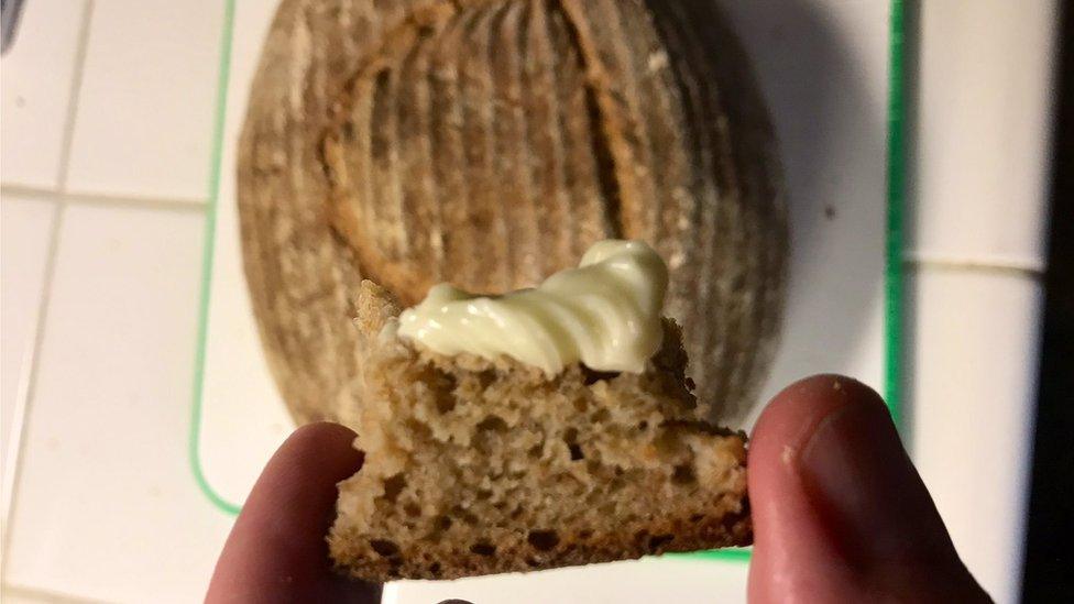 Crust of risen loaf with butter on it