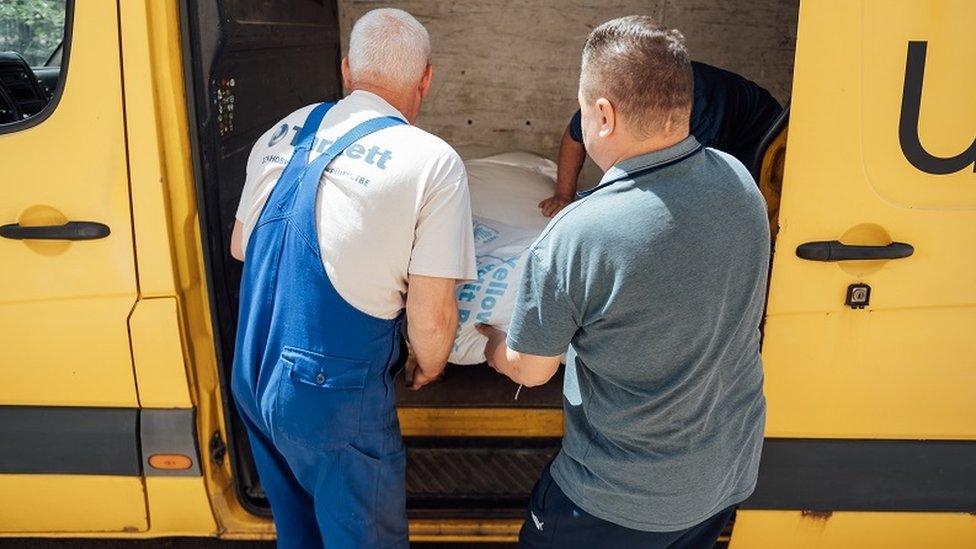 People unload supplies from an Uber van