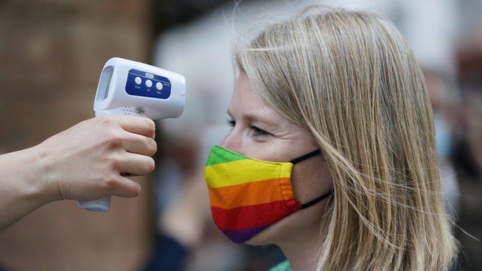 Woman having temperature tested outside theatre, 2 June