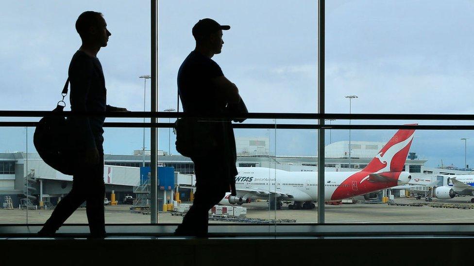 Two men walk through Sydney Airport