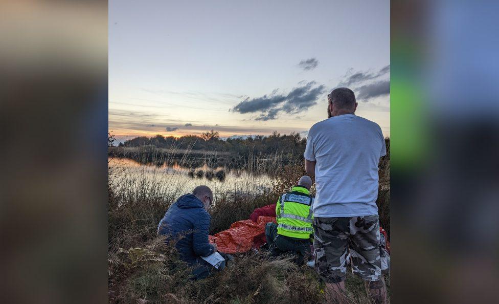 Photo of rescue teams helping the 73-year-old man with the sunset in the background