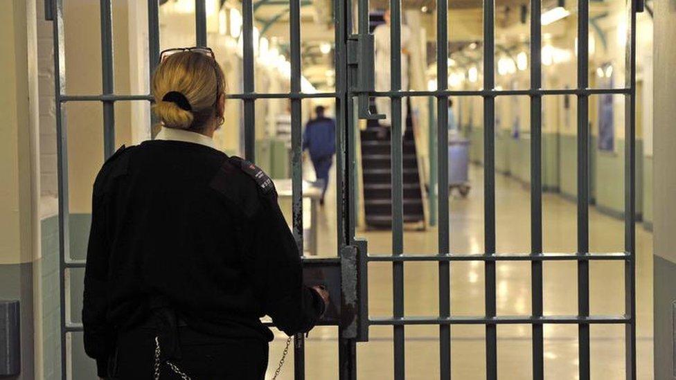 A prison officer at the doors of a prison