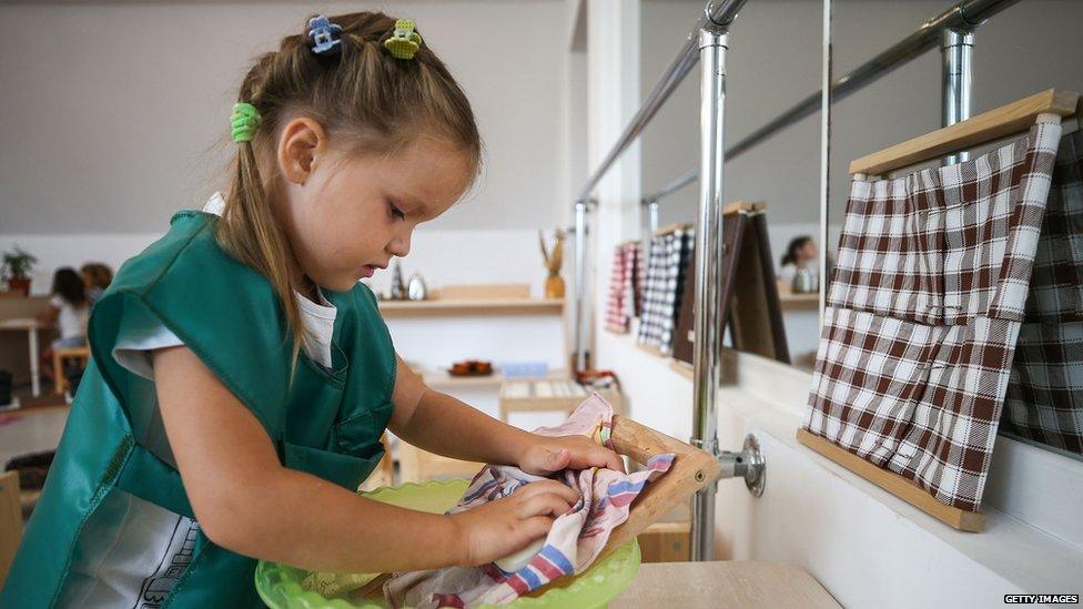 A girl learns to wash clothes during a lesson