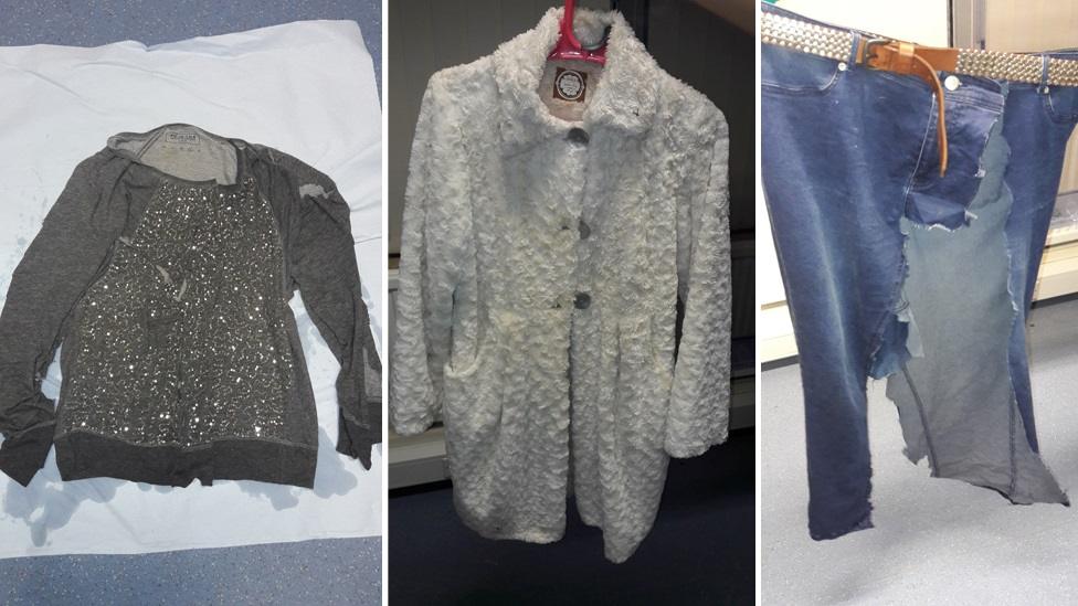 Dark blue jeans, with a brown leather belt patterned with metal studs, a grey long-sleeved top with a sequin pattern on the front, a white or cream faux fur coat.