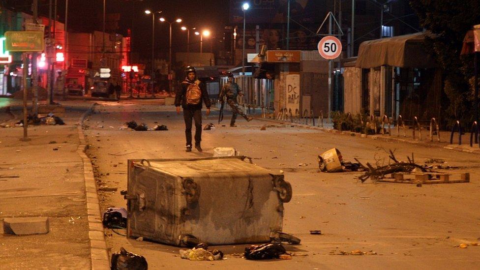 Police officers face demonstrators during clashes with security forces in the Ettadhamen city suburb of Tunis, Tunisia, 17 January 2021